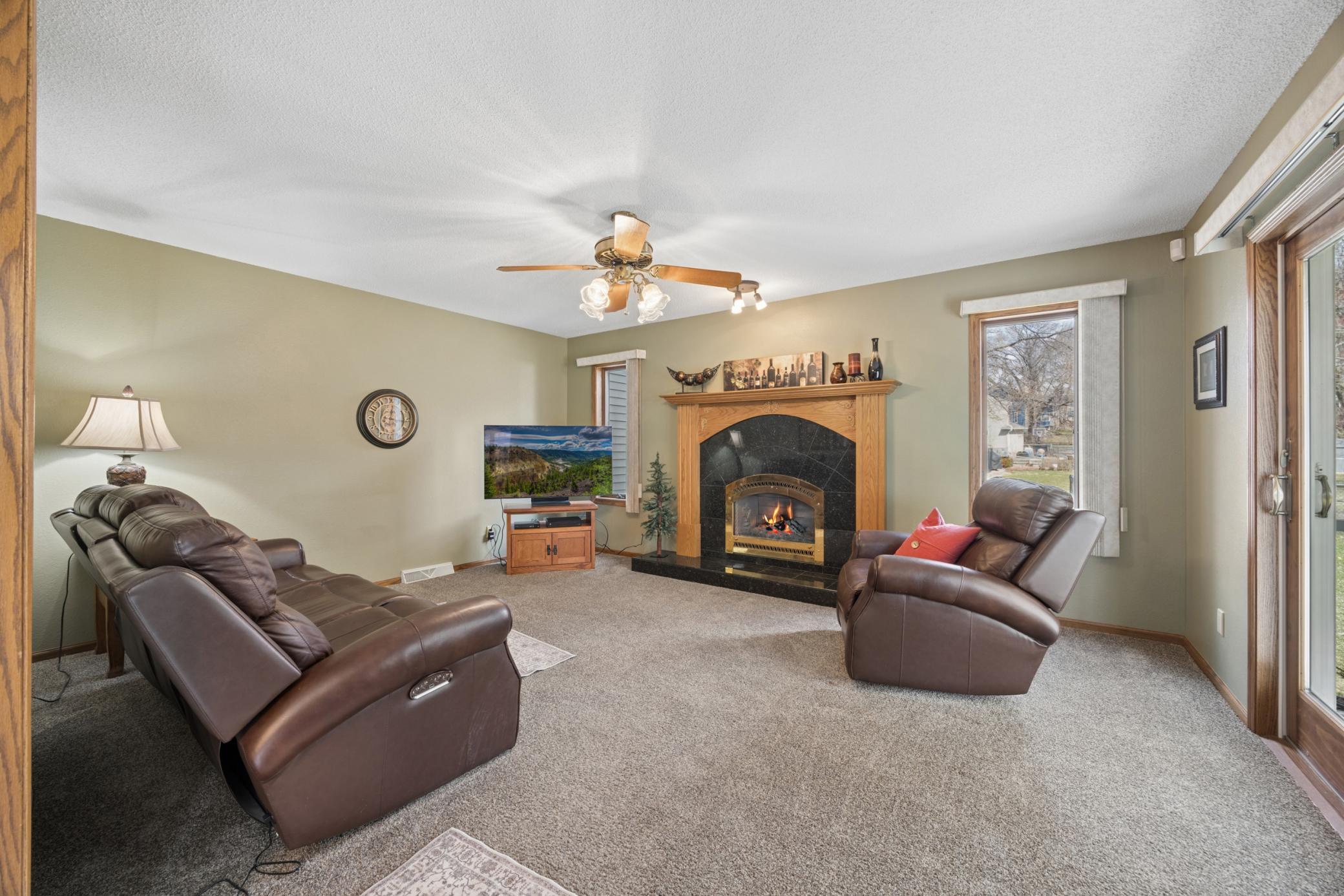 Family room with cozy gas fireplace and sliding doors leading to the screened in porch.