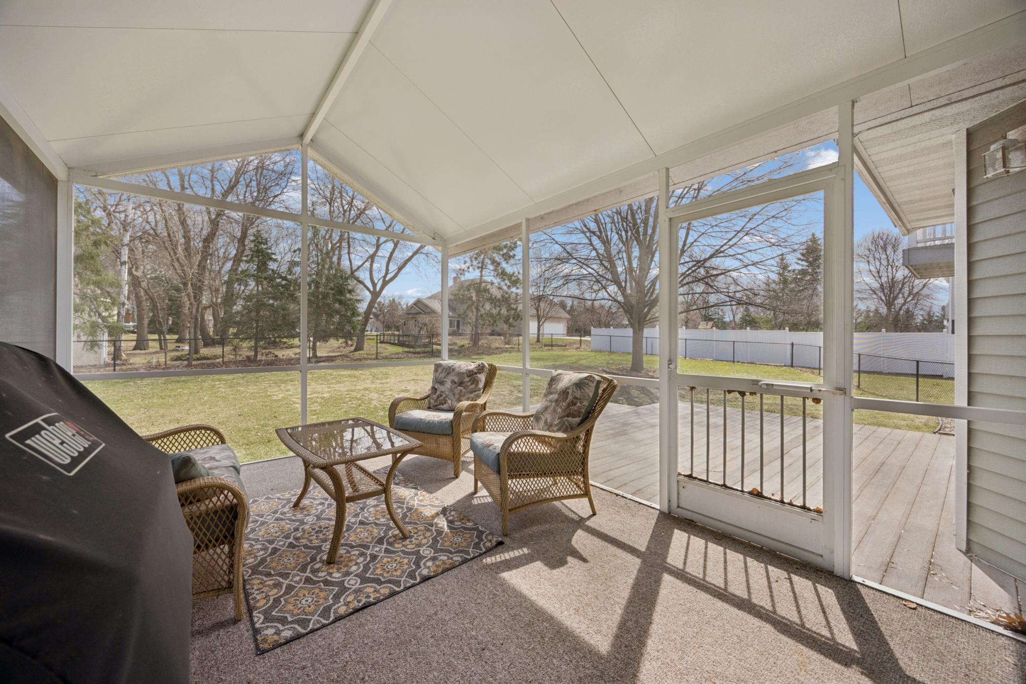 Screened in porch overlooking the fenced in backyard.