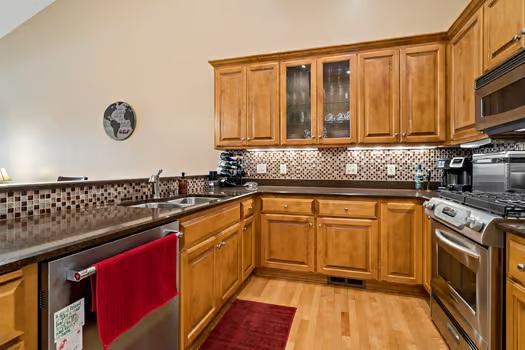 Kitchen w/ Cambria countertops, stainless steel appliances and hardwood flooring