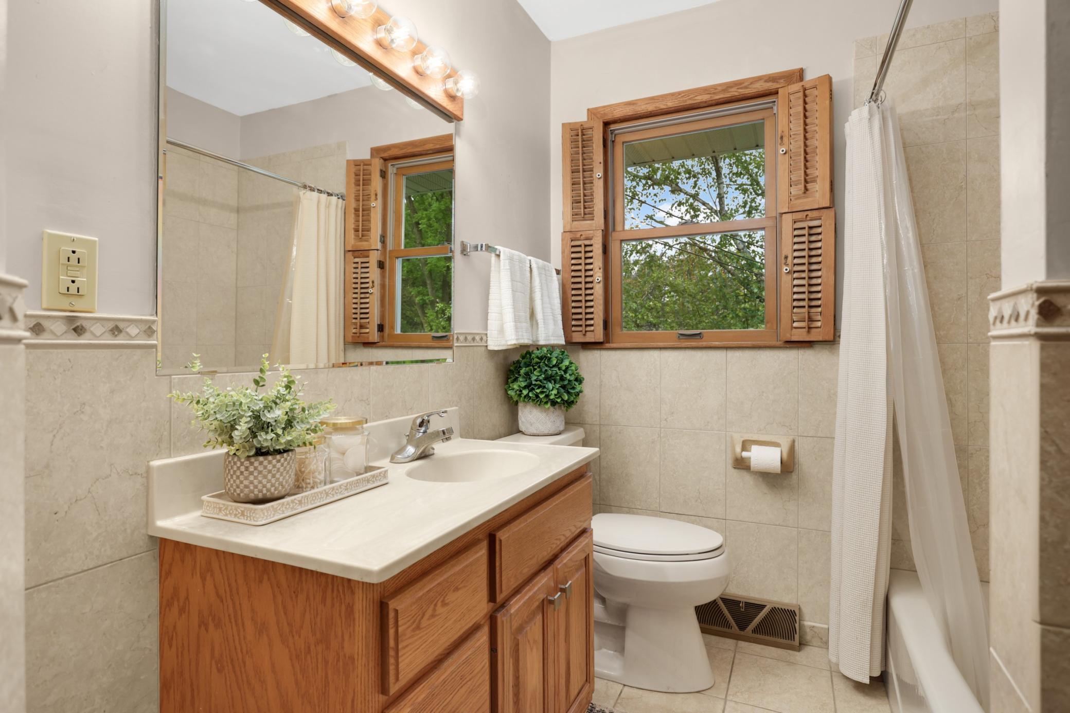 The main floor full bathroom is super functional and tidy and also features great linen storage behind the door.