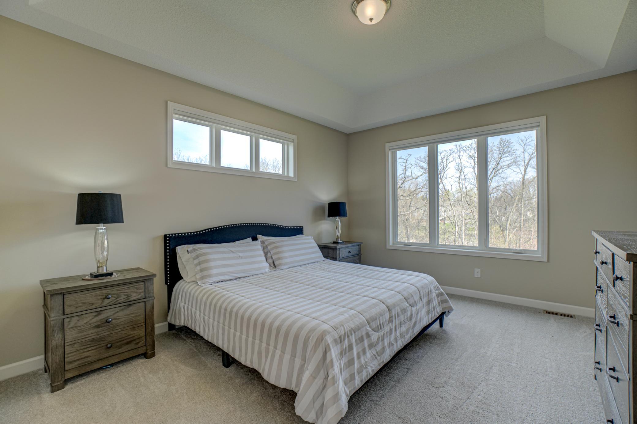 Retreat to the expansive primary suite, which offers a large walk-in closet and a private bath featuring a beautifully tiled walk-in shower