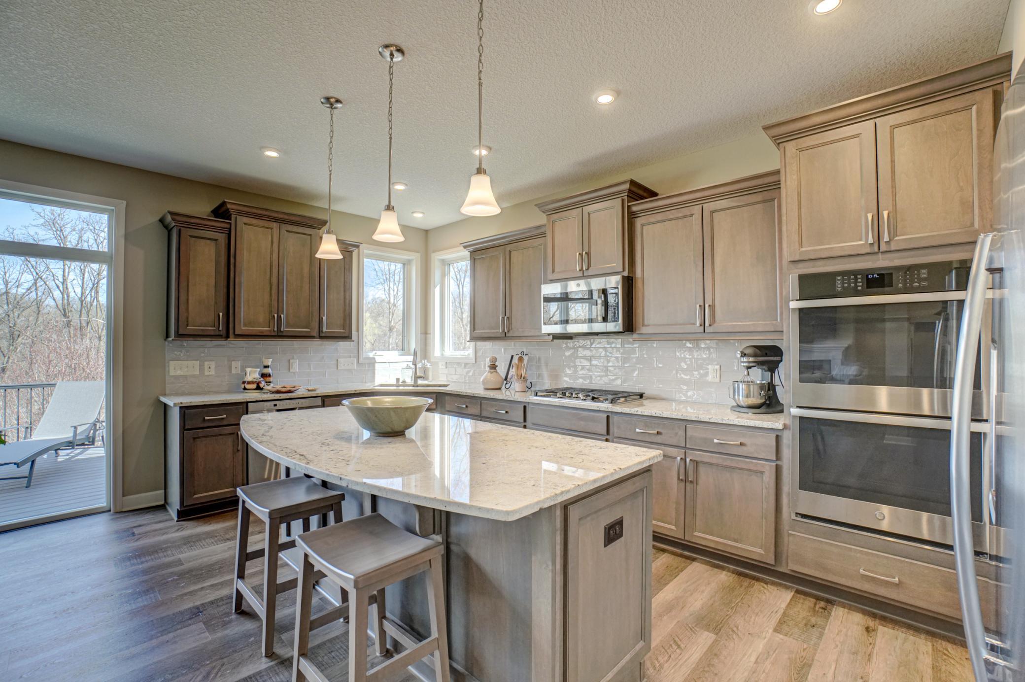 The upgraded center island kitchen is a true standout, complete with granite countertops, stainless steel appliances, and a generous pantry for added functionality