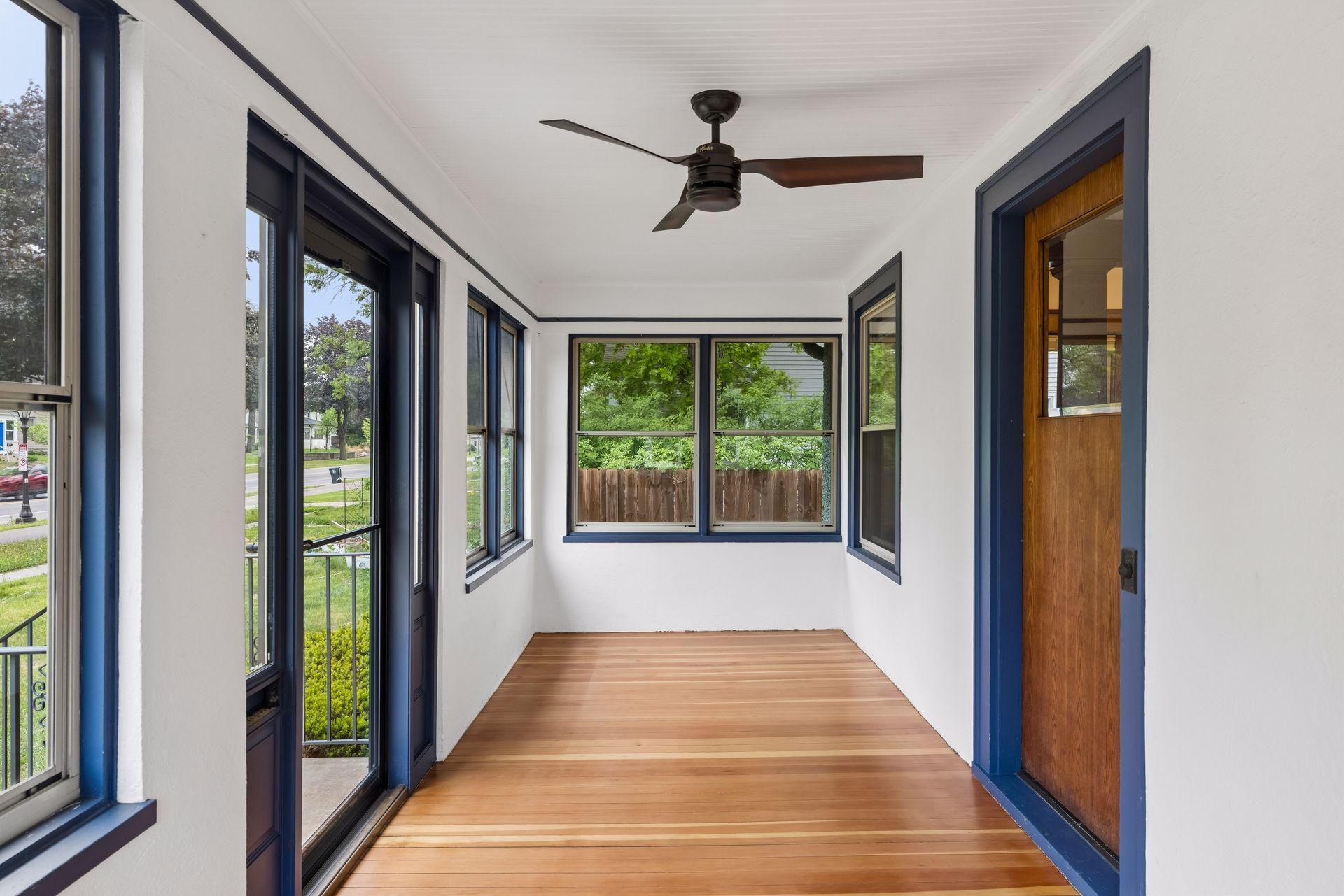 Charming south facing front porch with gleaming newly refinished hardwood floors.