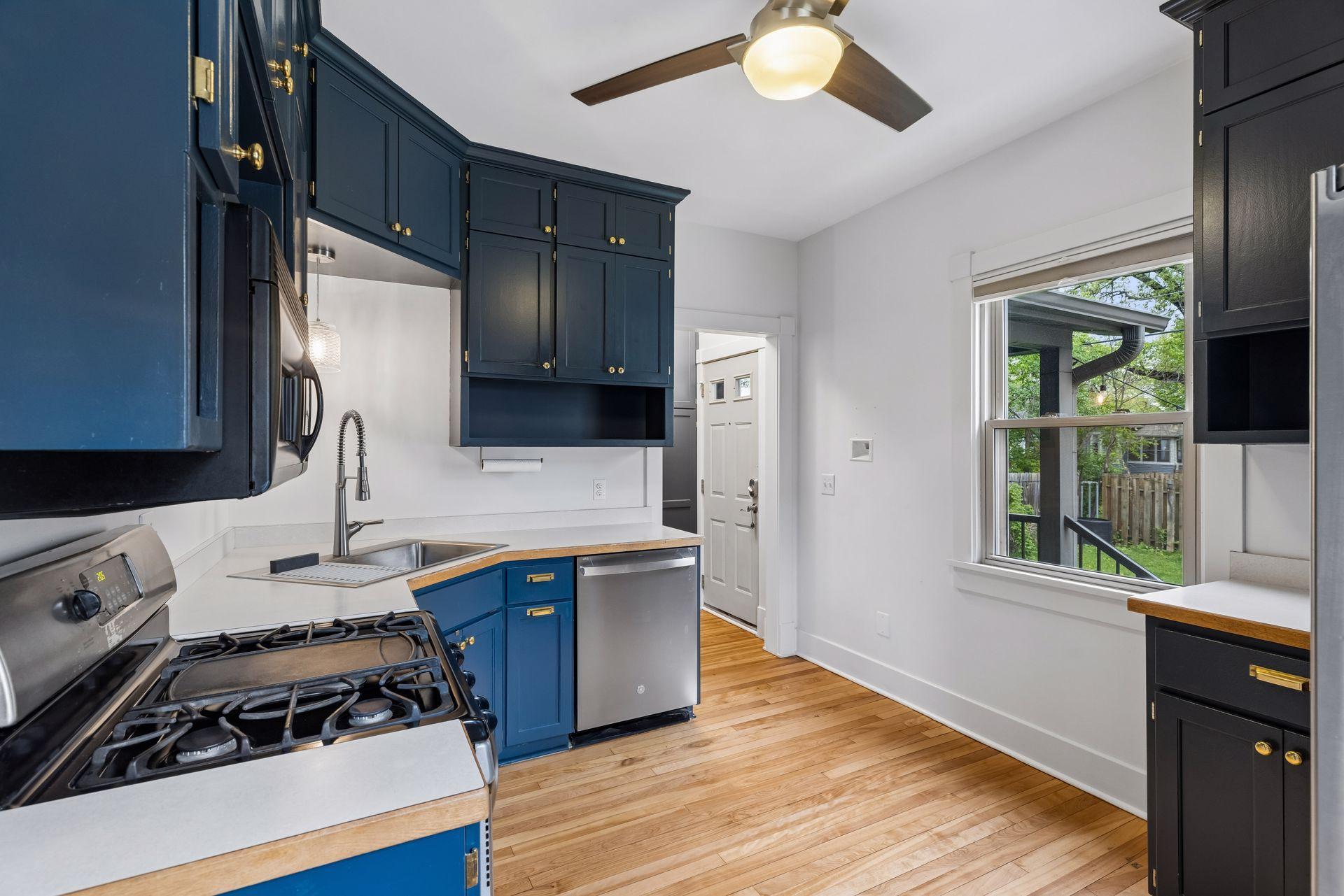 Crisp and clean baby blue and white kitchen with stainless steel appliances.