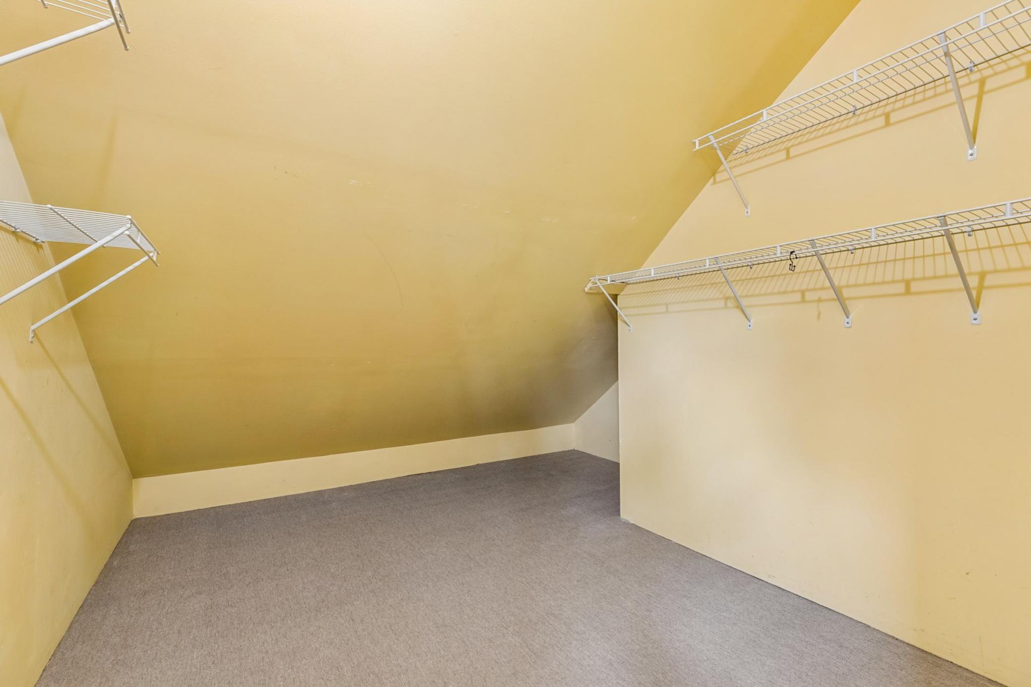 Versatile upper level walk-in closet or large storage room.