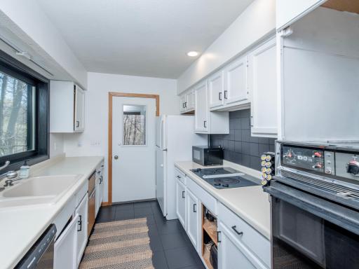 kitchen with freshly painted cabinets, door leads to screen porch