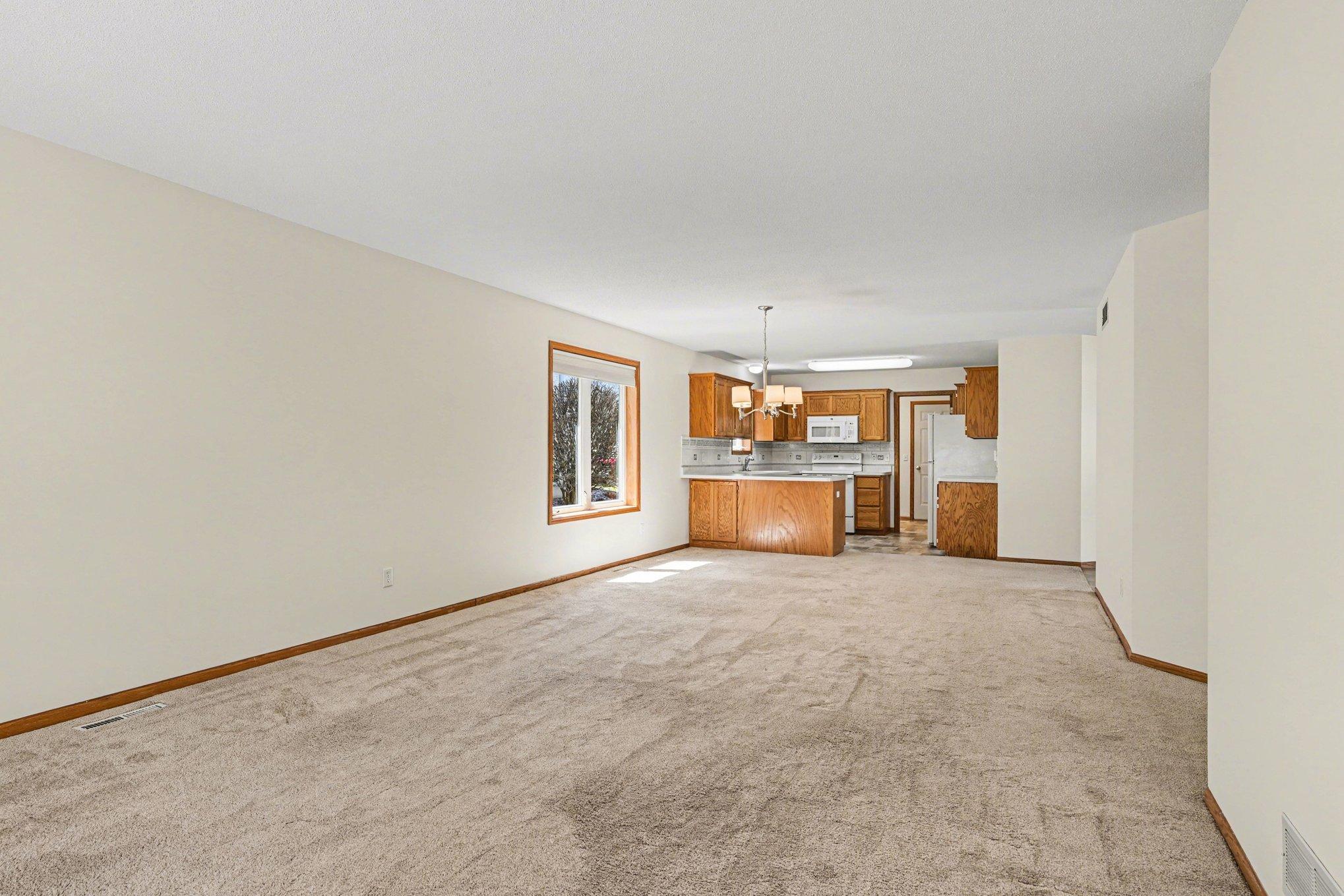 The spacious living area shines with natural light from large windows and patio doors. Fresh paint and professionally cleaned carpets make this open layout feel brand new and inviting—perfect for moving right in and making it your own!