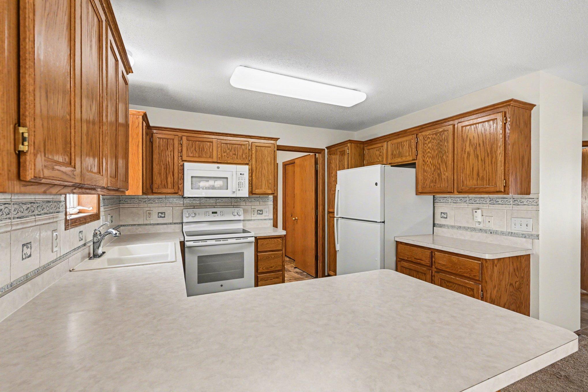 The kitchen comes fully equipped with a flat-top stove, microwave, dishwasher, and fridge. You'll love the abundant storage, featuring plenty of cabinets and a convenient two-level pantry for all your essentials.