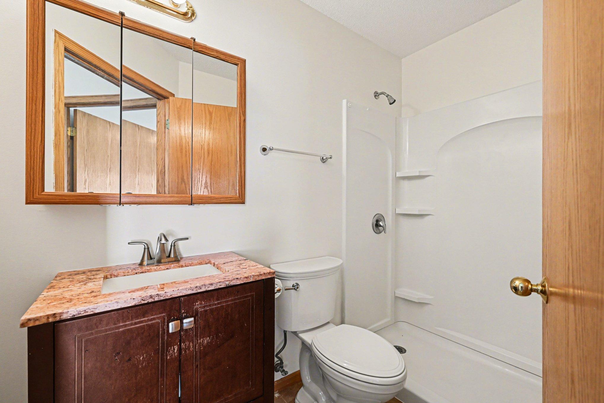 Located off the entrance, this 3/4 bath features a comfort-height vanity with storage, a medicine cabinet, and an easy step-in shower. A clean, functional design perfect for guests or daily use.