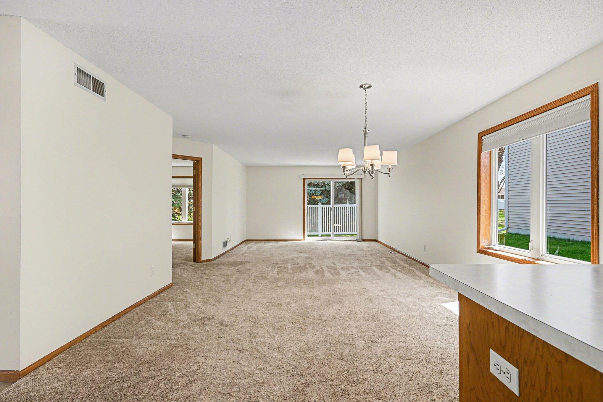 This view from the kitchen highlights the seamless flow between the dining and living areas. With the primary suite tucked just off the main room, this layout offers the perfect balance of open entertaining space and private living.