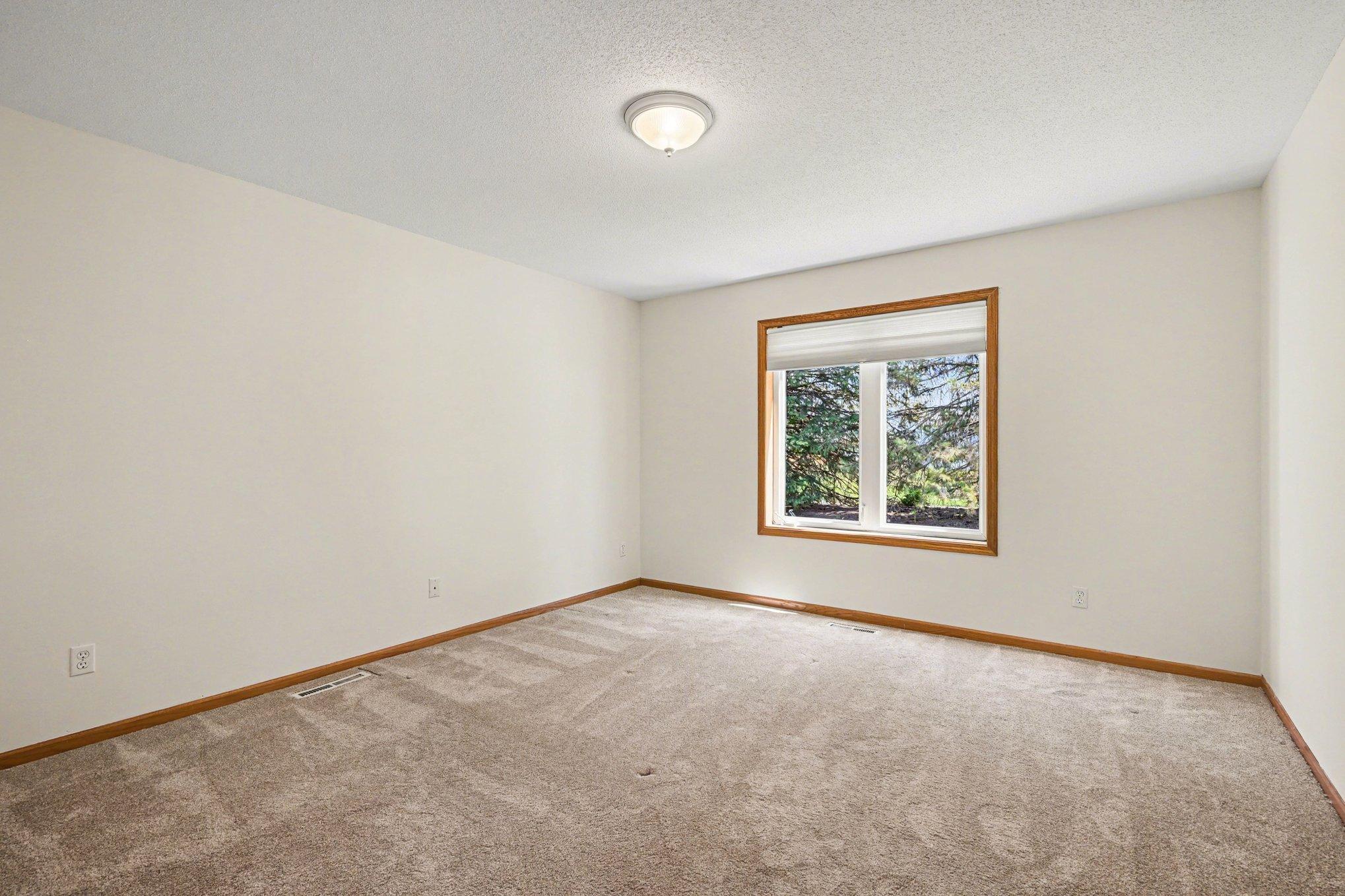 The primary suite offers a private retreat with views of the pine-lined yard. Tucked off the living room, this spacious room features a walk-in closet and its own private full bath.