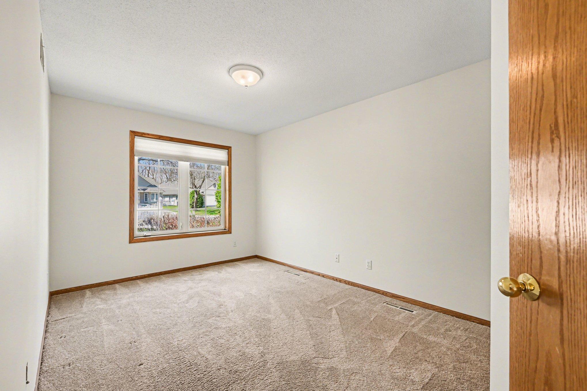 Located near the entrance, the second bedroom features a large window and spacious closet. Whether used as a guest room or a home office, this bright, versatile space is freshly painted and move-in ready. The perfect flexible addition to your home!