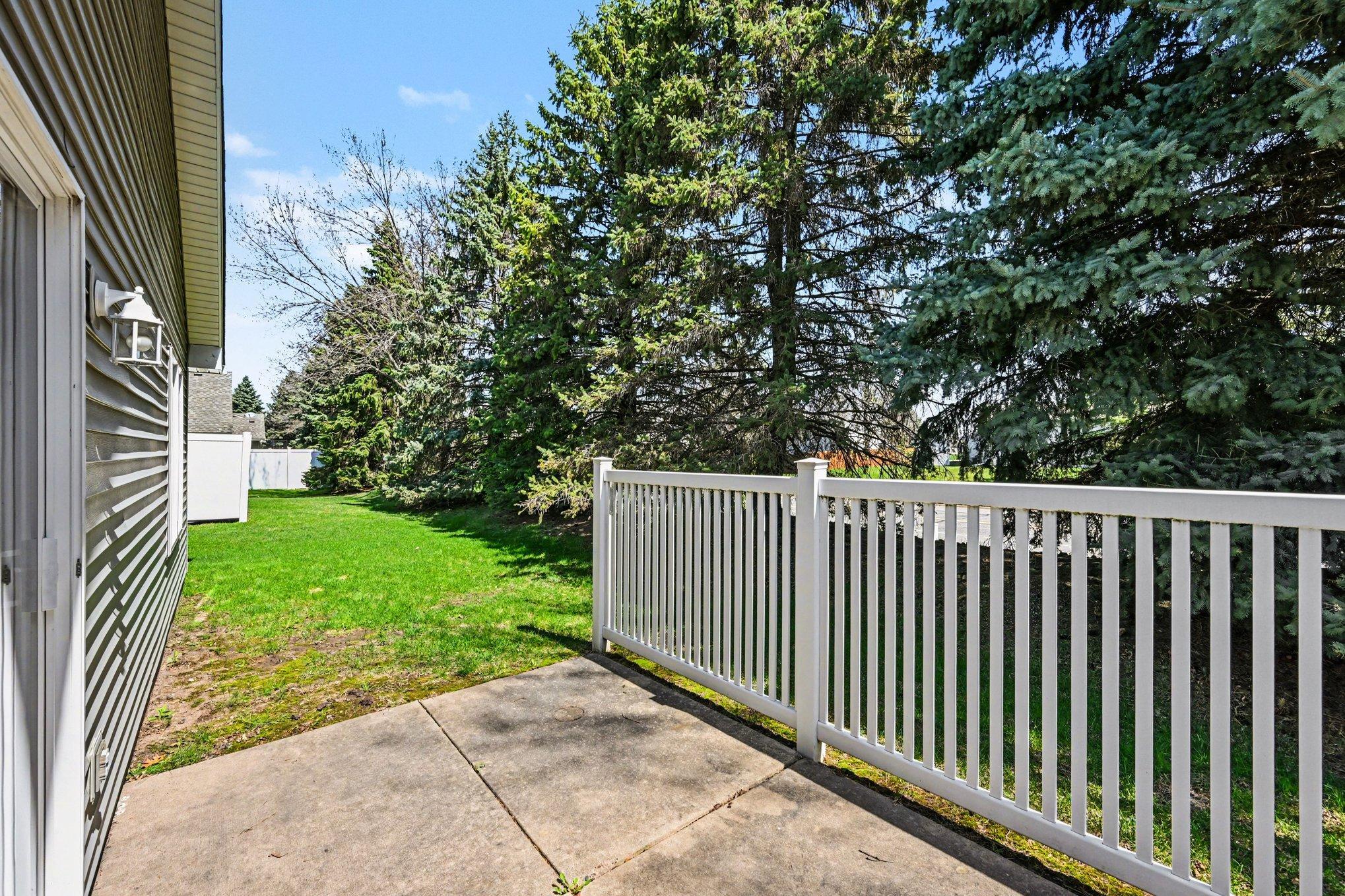 Enjoy the beautiful weather on your private patio, framed by mature pines and a partial fence. This serene outdoor space is perfect for kicking back and relaxing in a quiet, natural setting. Your own peaceful retreat awaits!
