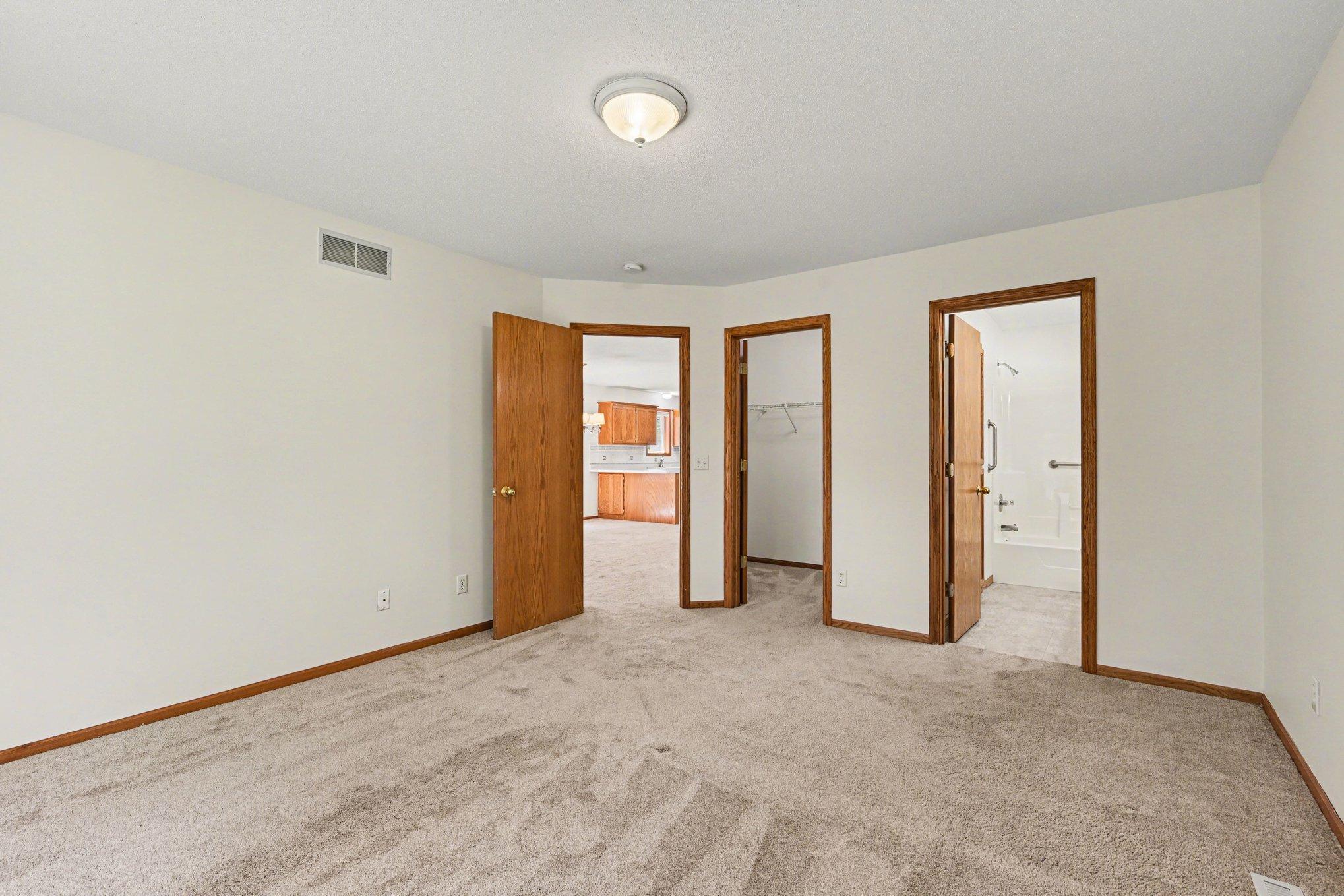 This view shows the primary bedroom’s smart layout, located just off the living room. It highlights easy access to the spacious walk-in closet and private full bathroom. A perfectly designed retreat for convenience and comfort!