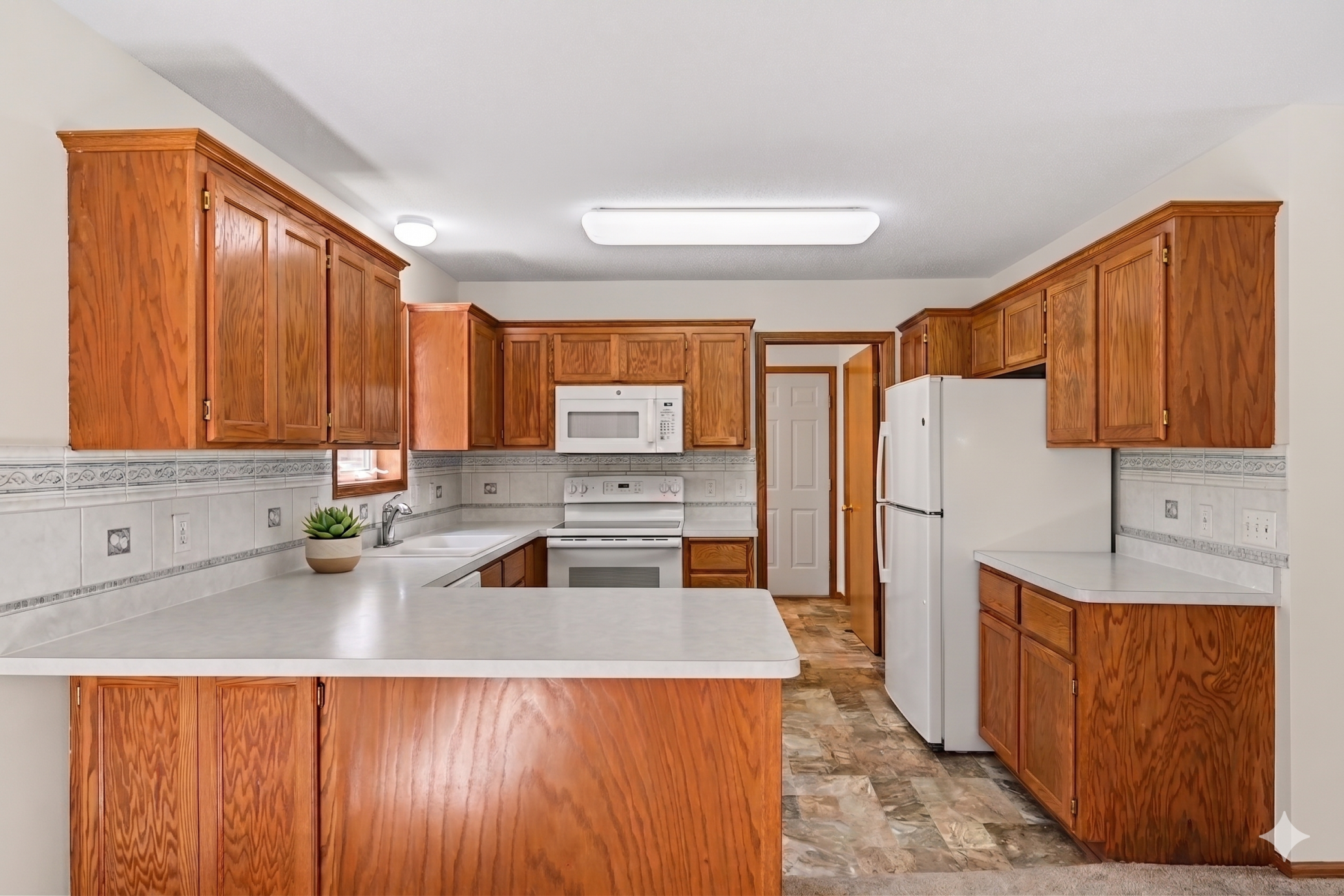 The kitchen offers abundant cabinet and counter space, plus a bright window for natural light. Conveniently located just steps away, you’ll find the laundry room/mud room and easy access to the garage. A functional layout designed for easy living!