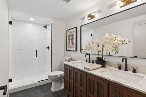 Lower level bathroom with dual sinks and a spacious layout for easy morning routines.