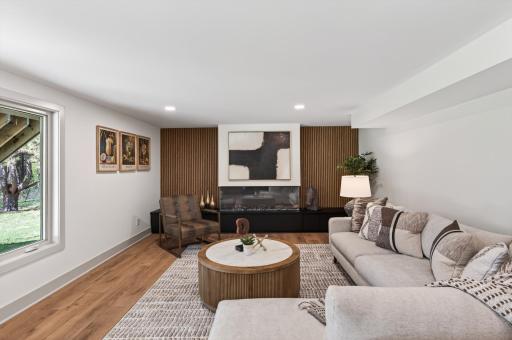 The slat accent wall and 65â 3 sided electric fireplace perfectly complement the main level design aesthetic.