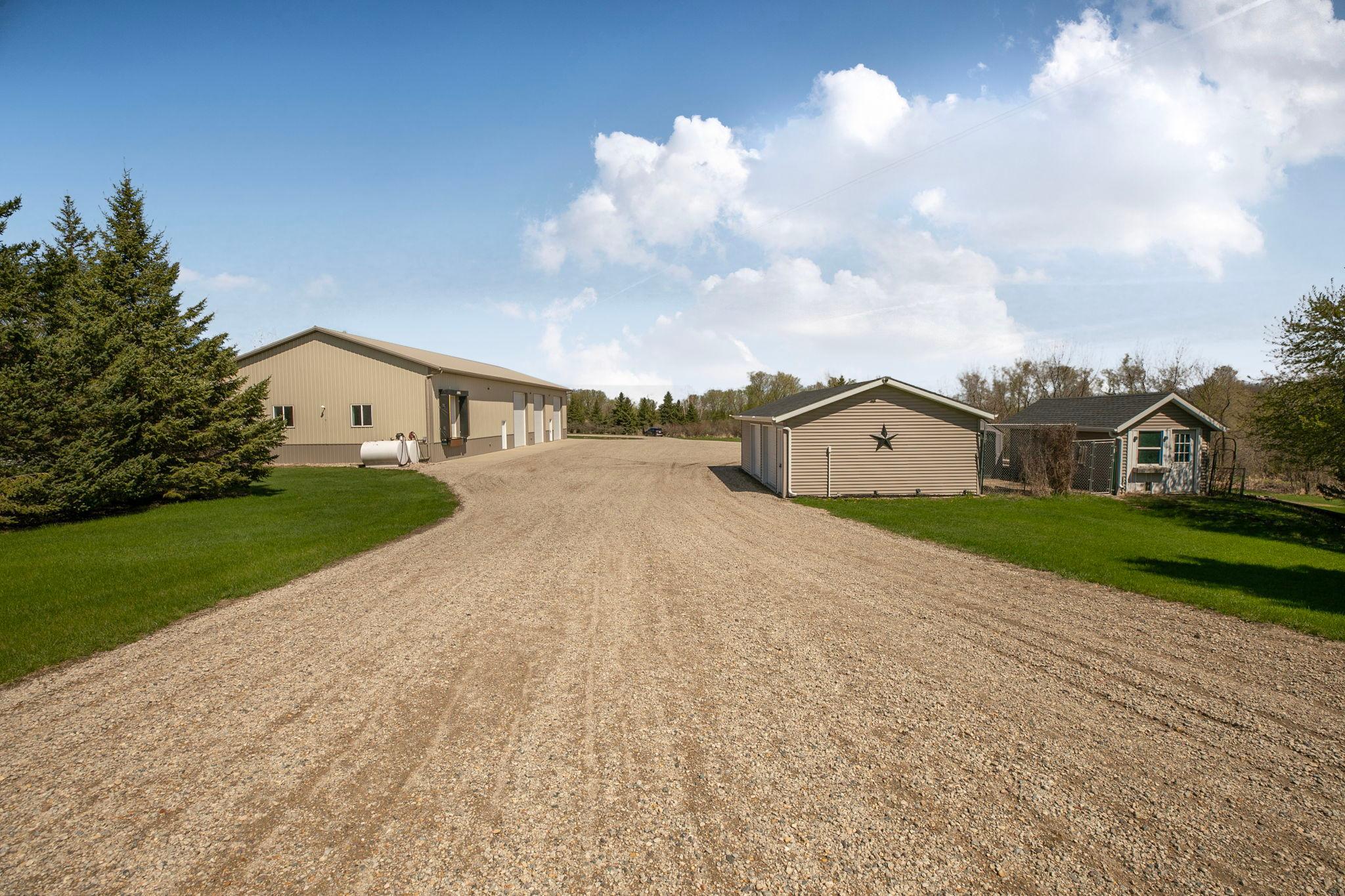 View of the detached garage, chicken coop and large outbuilding.