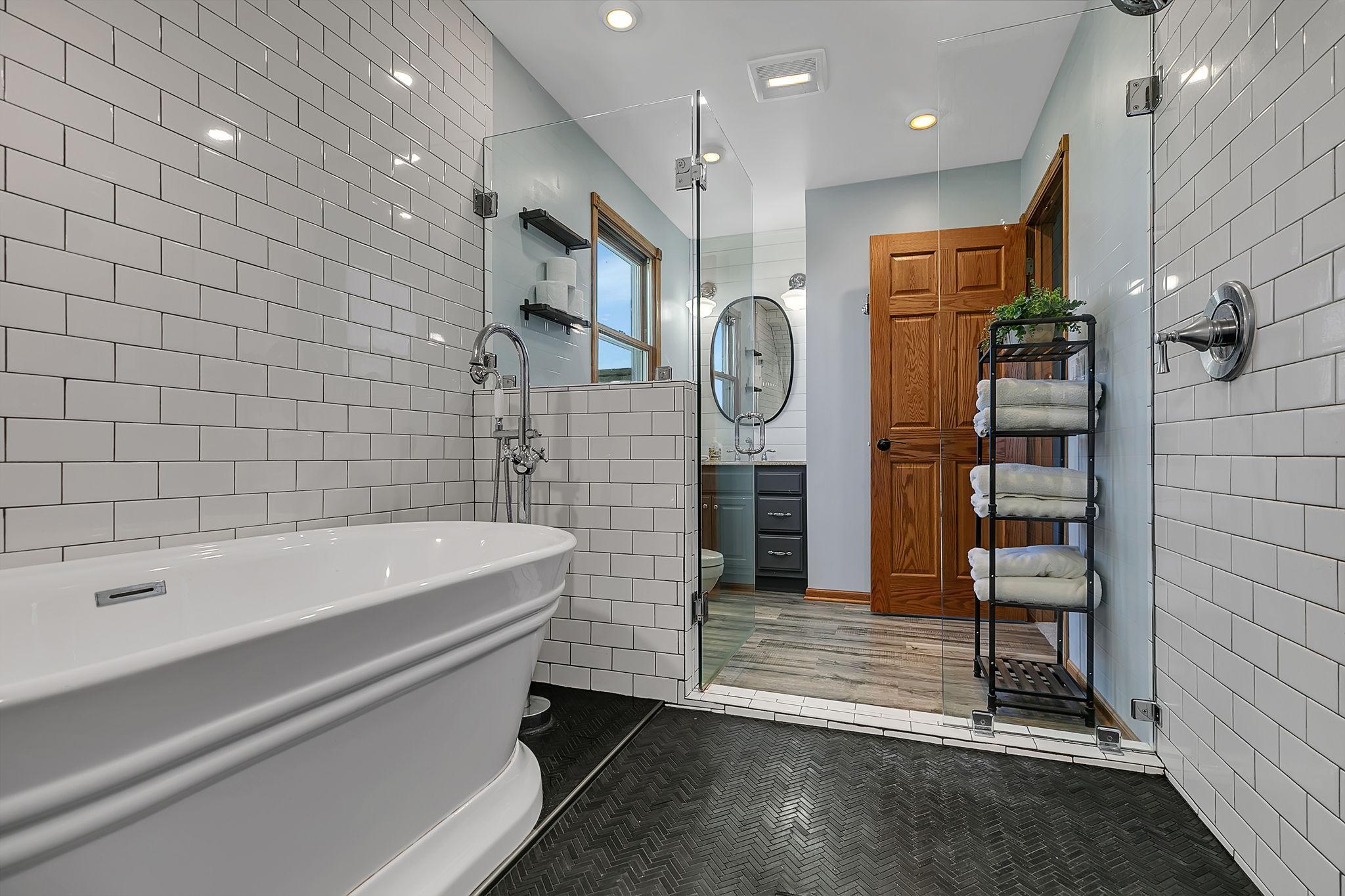 The beautiful en suite with soaking tub, subway tile and glass enclosed double shower - provides a relaxing, spa-like feel!