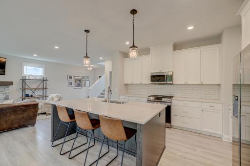 A sleek, stylish kitchen offers stainless steel appliances, a clean backsplash, and an oversized center island that connects effortlessly to the main living spaces, making it ideal for both daily living and hosting.