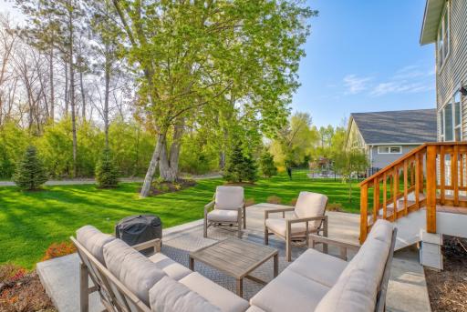 Outside, a beautiful yard with a concrete patio extends your living space, offering peaceful wooded privacy, with a walking trail just steps away.