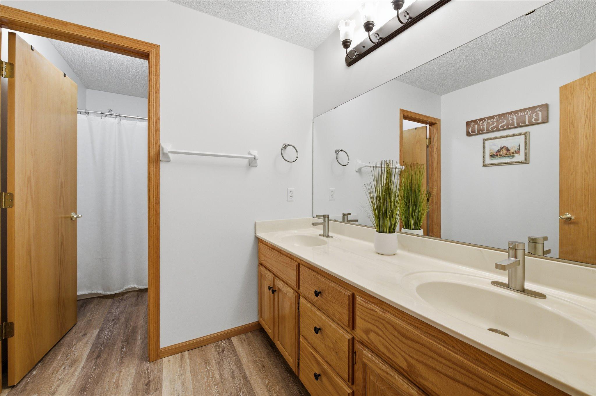 Upper floor hallway bath features dual sinks