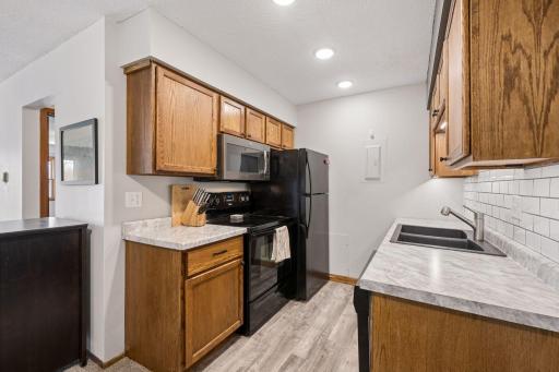 An efficient galley style kitchen, full size appliances and some countertop work space.