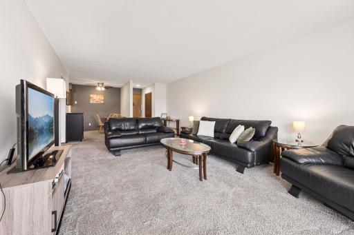A view showing the large living room and beyond into the entry hall and dining area.
