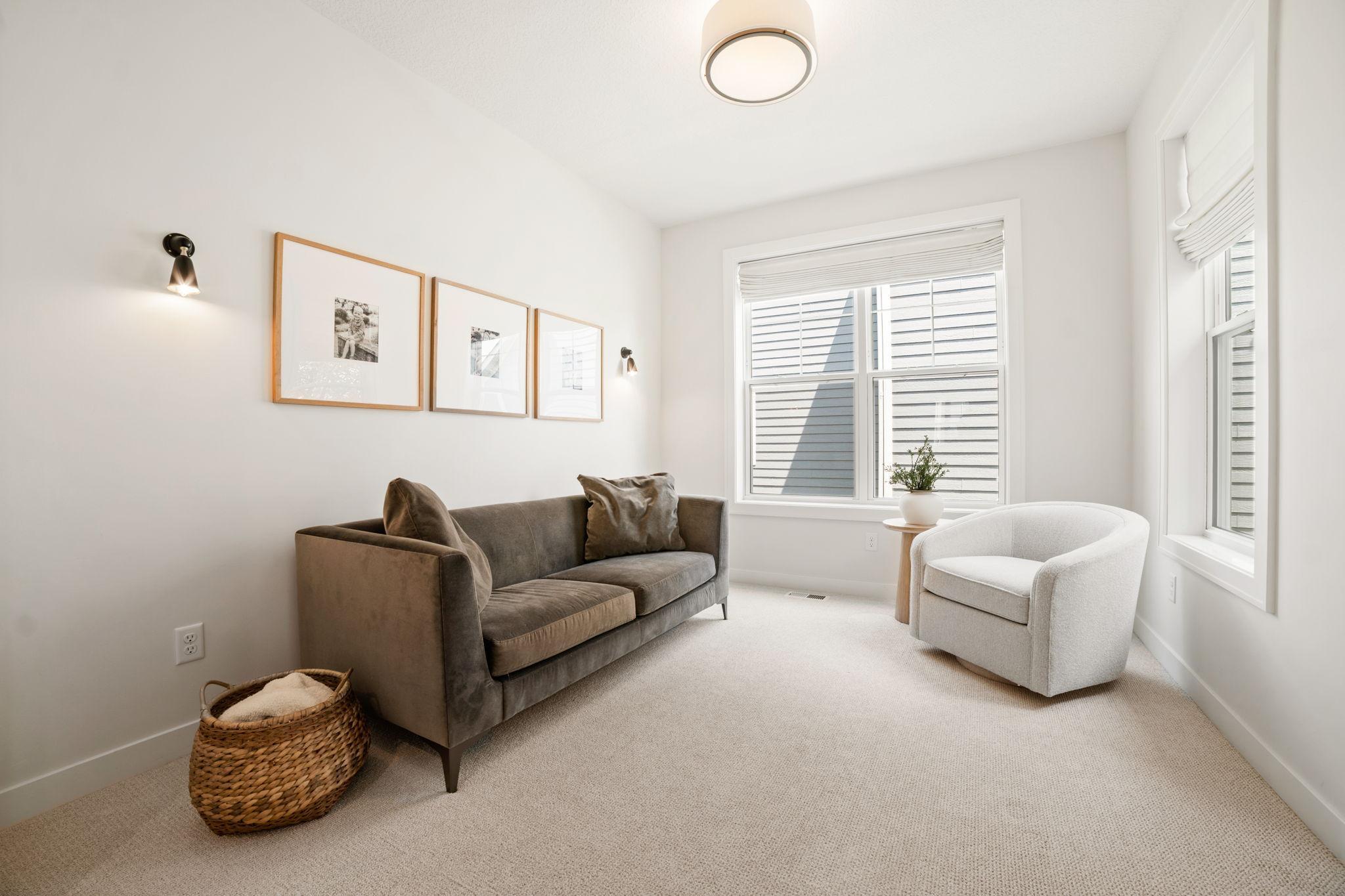 Sitting Room features decorative wall sconces and carpet flooring