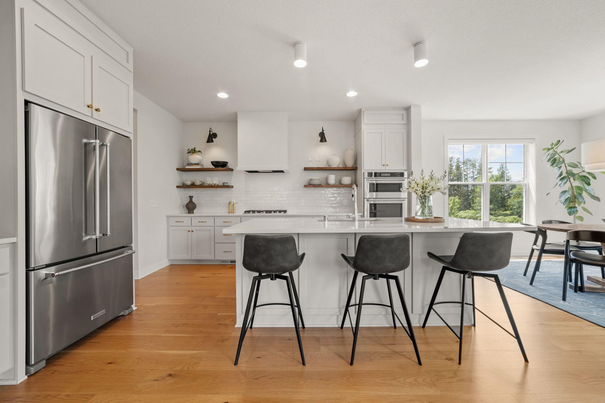 Kitchen offers enameled cabinetry that features flat panel doors, roll-out storage, floating display shelving made of alder and "Eat-In" center island