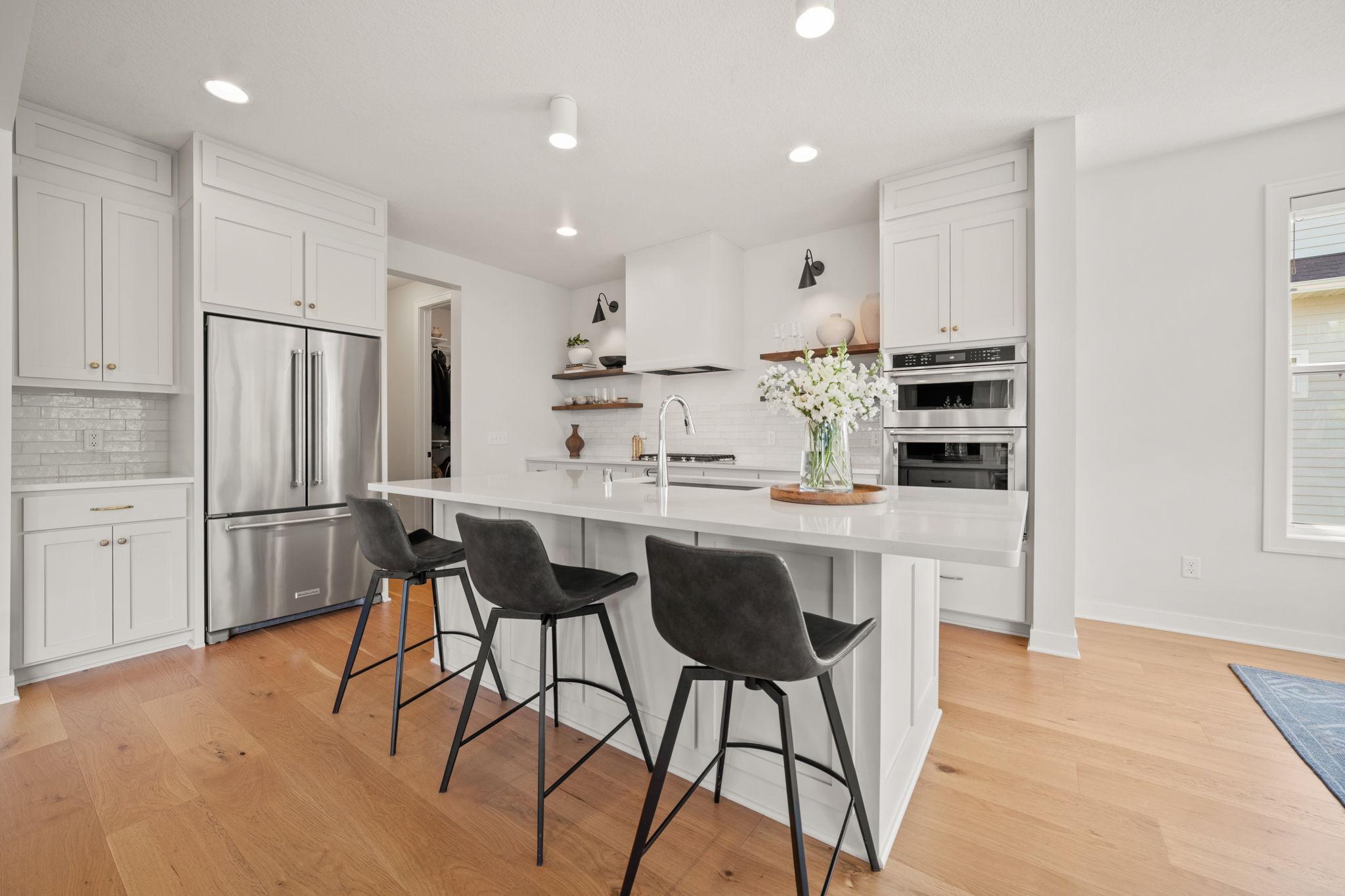 Professional KitchenAid stainless steel appliances include a French Door refrigerator, gas cooktop with decorative hood, wall oven and convection microwave combo and dishwasher