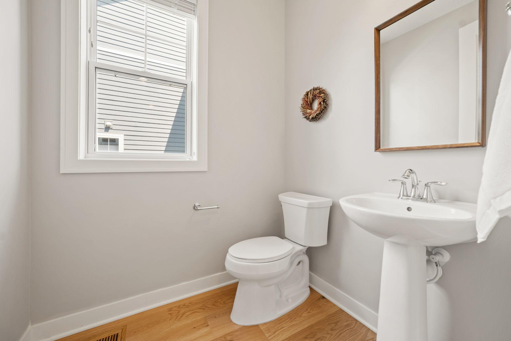 1/2 bathroom on the main level features pedestal sink and natural light