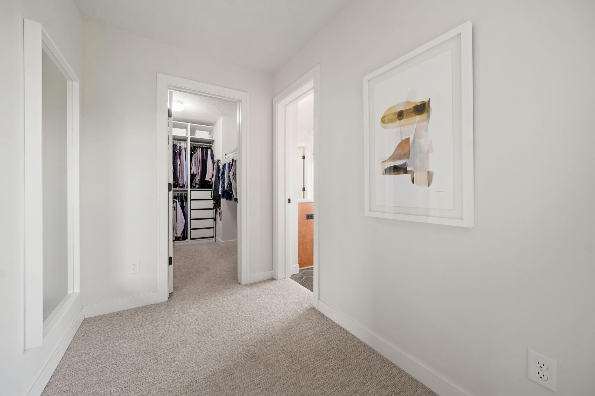 Generously sized walk-in closet features professionally installed organizer