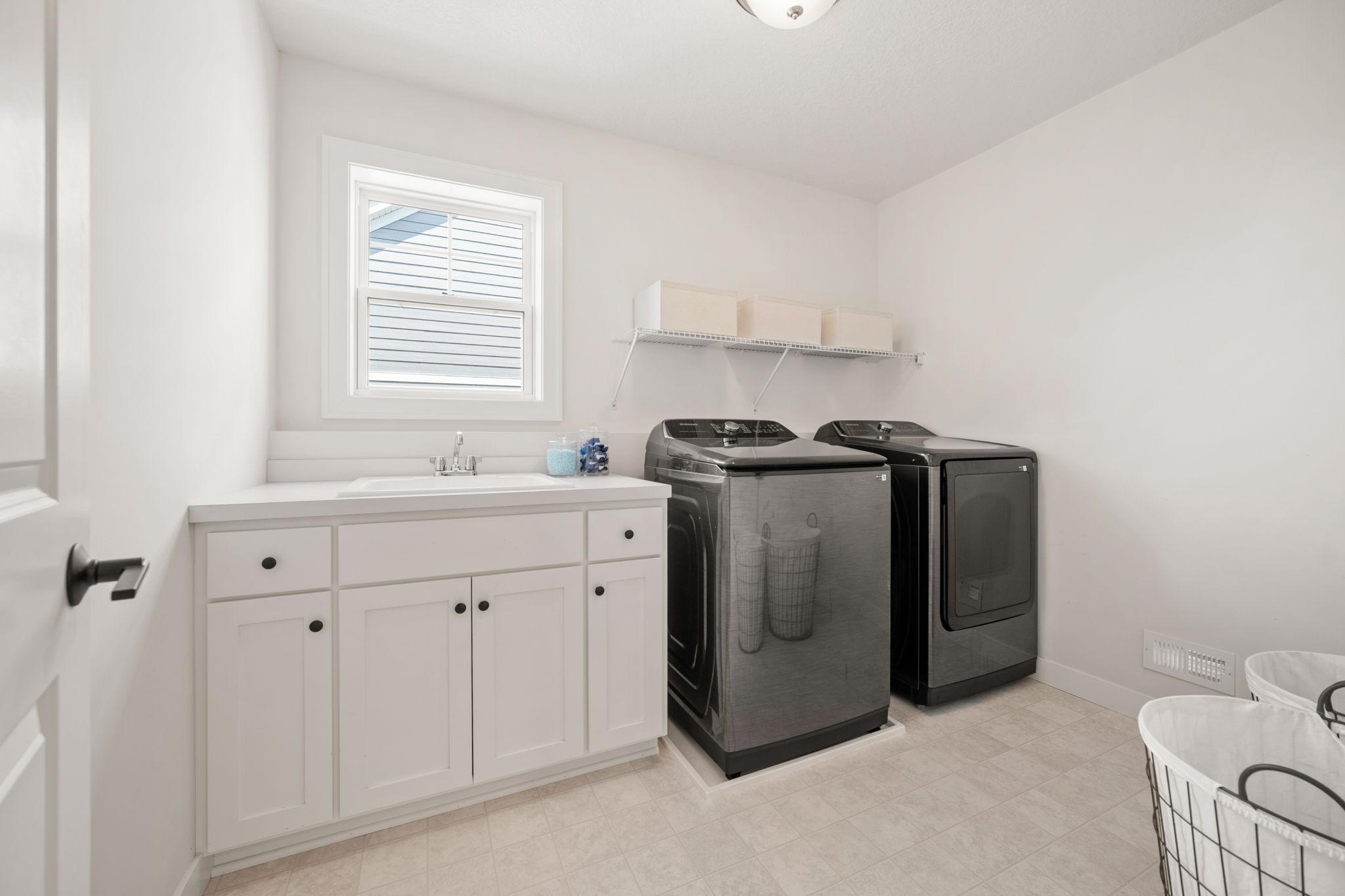Laundry Room is open & bright! Enameled cabinet w/ drop-in utility sink