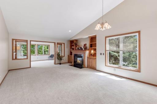 Enjoy comfortable, open-concept living with vaulted ceilings, elegant built-ins, and a cozy fireplace framed by rich woodwork.