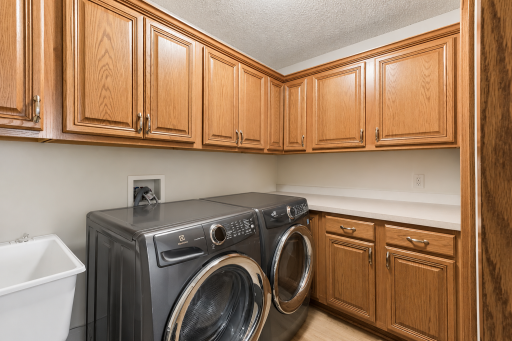 Convenient main-level laundry includes abundant cabinetry, countertop workspace, and storage to help keep household tasks organized and efficient.