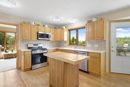 The kitchen features custom cabinetry, solid surface countertops and stainless steel appliances.