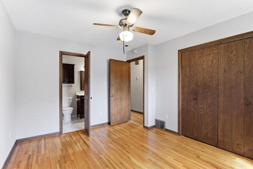 Direct bathroom access, a wide closet, and hardwood floors give this bedroom flexibility for use as a primary bedroom, guest bedroom, or home office.