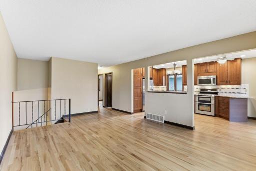 A pass-through opens the gathering room to the kitchen counters and stainless-steel range, with the bedroom hallway just beyond.