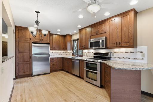 Stunning counters, a stainless steel appliance suite, and warm wood cabinetry shape a kitchen built for daily cooking and easy weekend hosting.