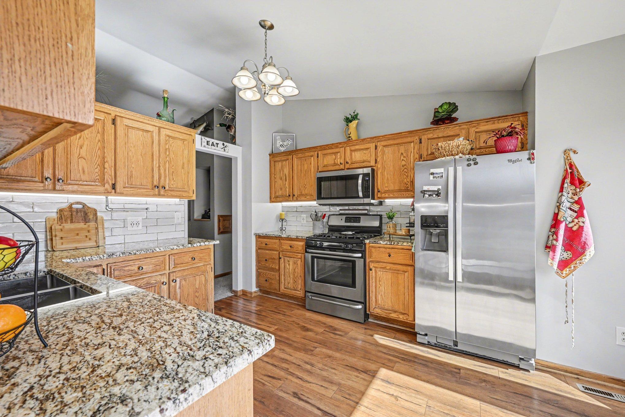 Granite counters surrounding kitchen w/ gorgeous backsplash