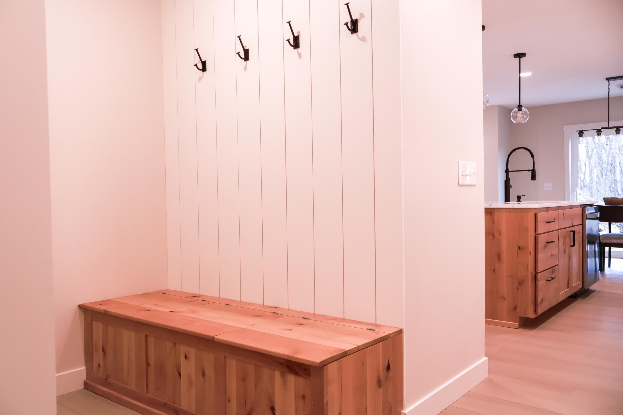 Entry from garage has storage bench and hooks