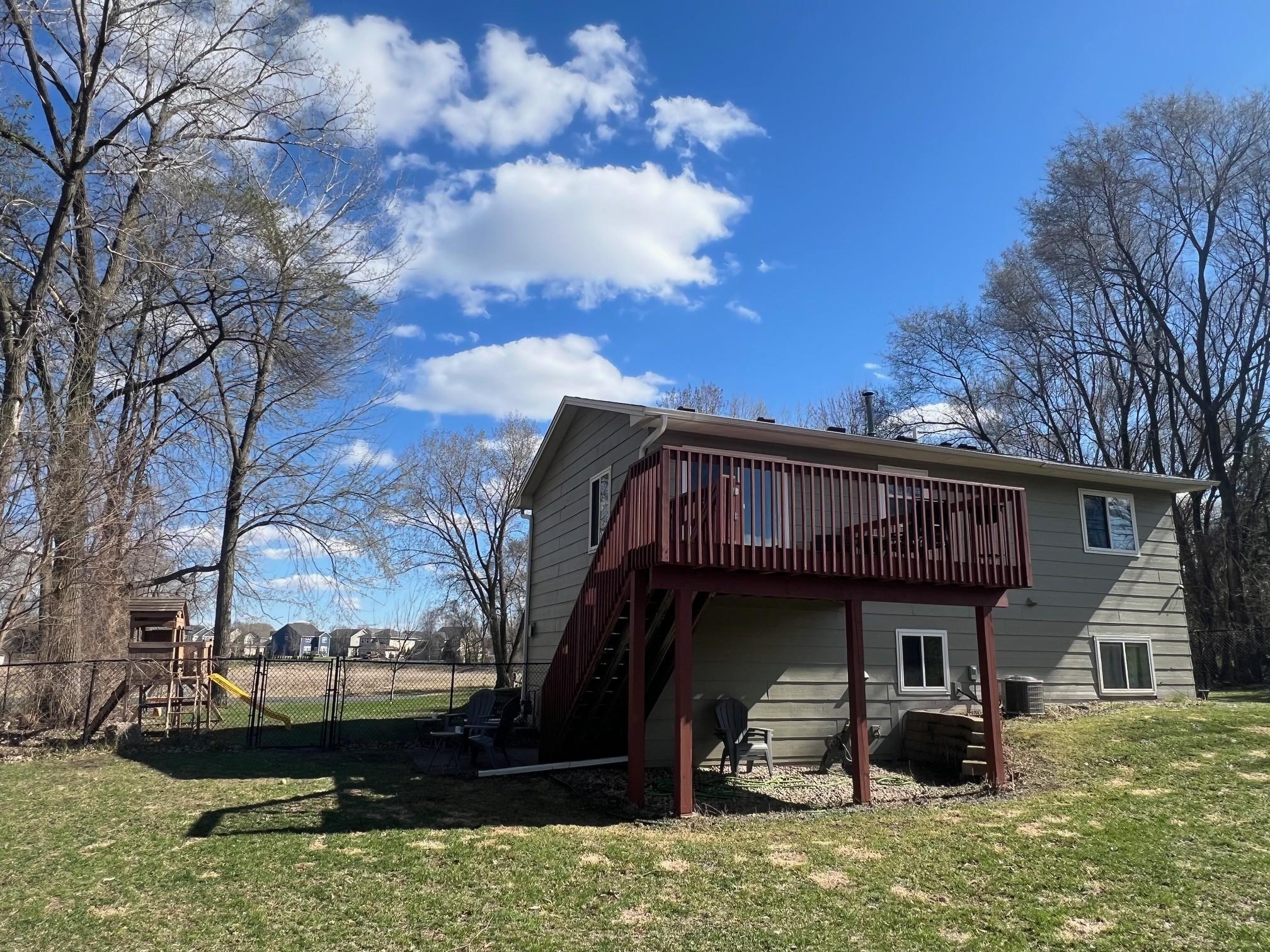 Fully-fenced backyard and large deck that has been recently stained.