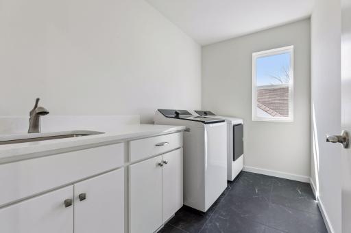Convenient upper-level laundry room with washer and dryer, soft-close cabinetry, and energy-efficient setup. Well-designed space offering functionality and everyday convenience.
