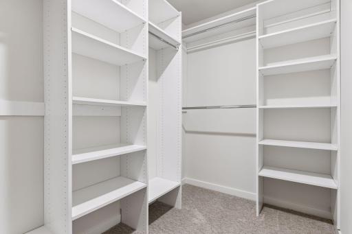 Spacious walk-in closet in the primary bedroom featuring custom shelving and ample hanging space, designed for easy organization and maximum storage.