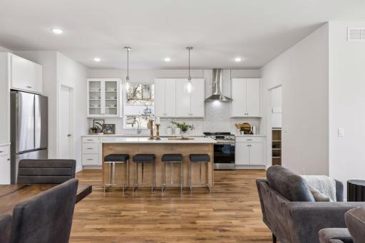 Open kitchen featuring a spacious breakfast bar area, perfect for casual dining, morning coffee, or entertaining. Seamlessly connected to the living space with hardwood floors and abundant natural light.