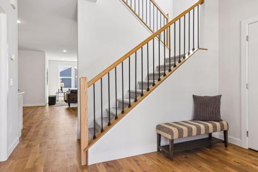 Bright and welcoming foyer with open staircase, custom railing, and durable 3/4" white oak hardwood floors flowing throughout the main level. Clean lines and natural light create a warm first impression.