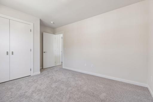 Alternate view of the third bedroom showcasing comfortable layout, closet space, and clean, modern design.