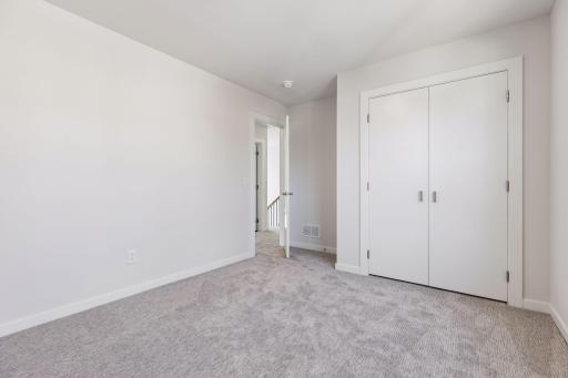 Alternate view of the fourth bedroom showcasing spacious layout, closet storage and clean, modern design.