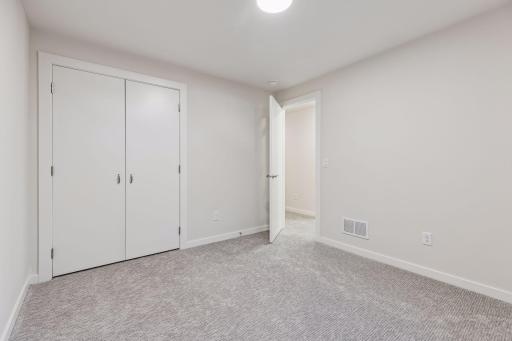Alternate view of the fifth bedroom showcasing comfortable layout, closet storage and clean, modern finishes.